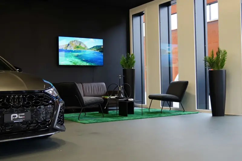 Lounge area in the showroom with seating and a screen